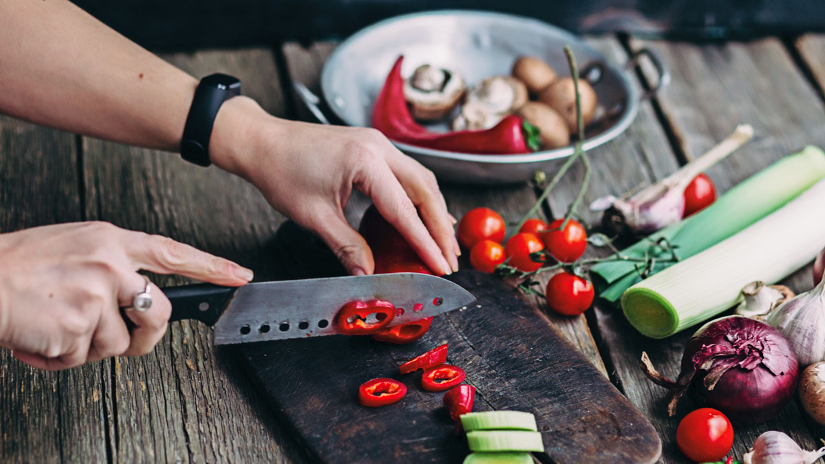 Female Hands Cut Vegetables On The Board. Cooking Vegetarian Foo