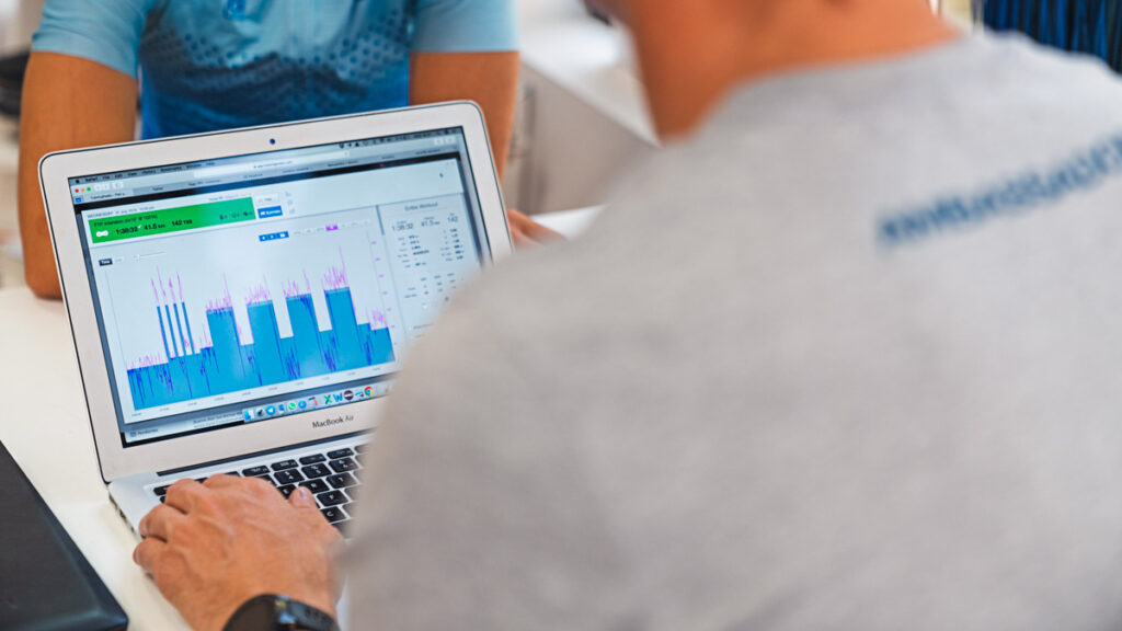 an endurance coach looking at workout data in TrainingPeaks on his laptop