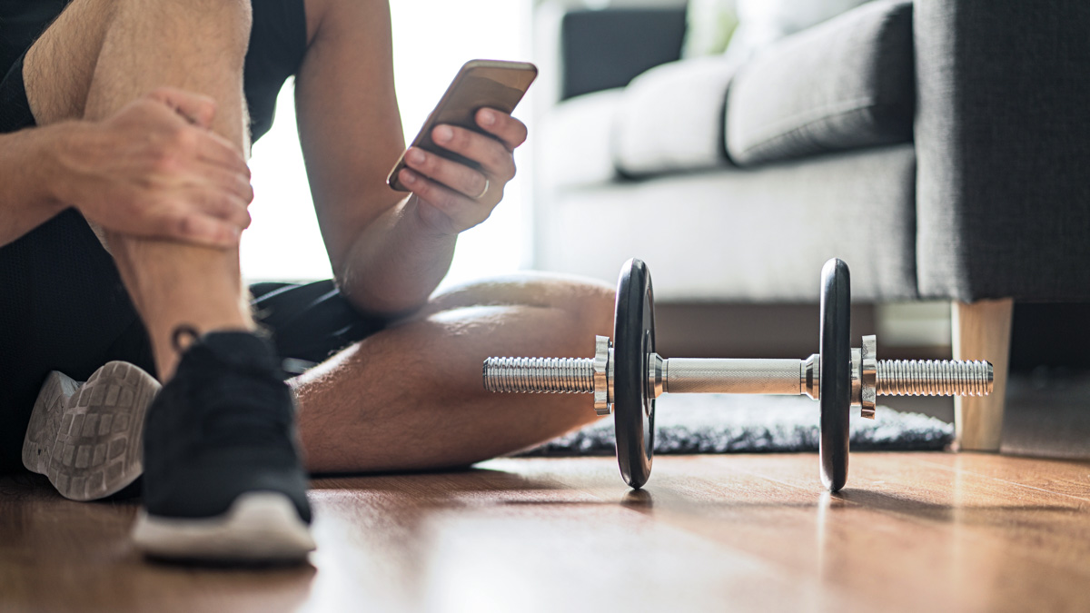 Man Using Smartphone During Workout At Home. Online Personal Tra