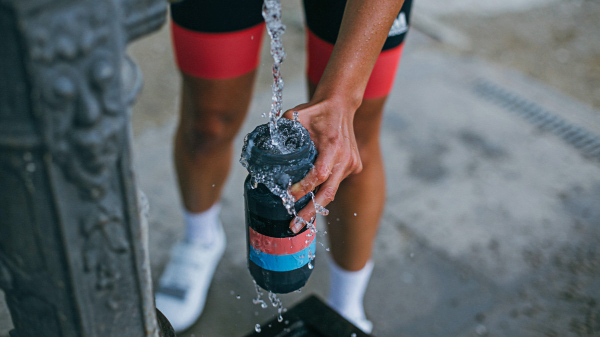 Cyclist Filling Bottle From Fountain In Spain