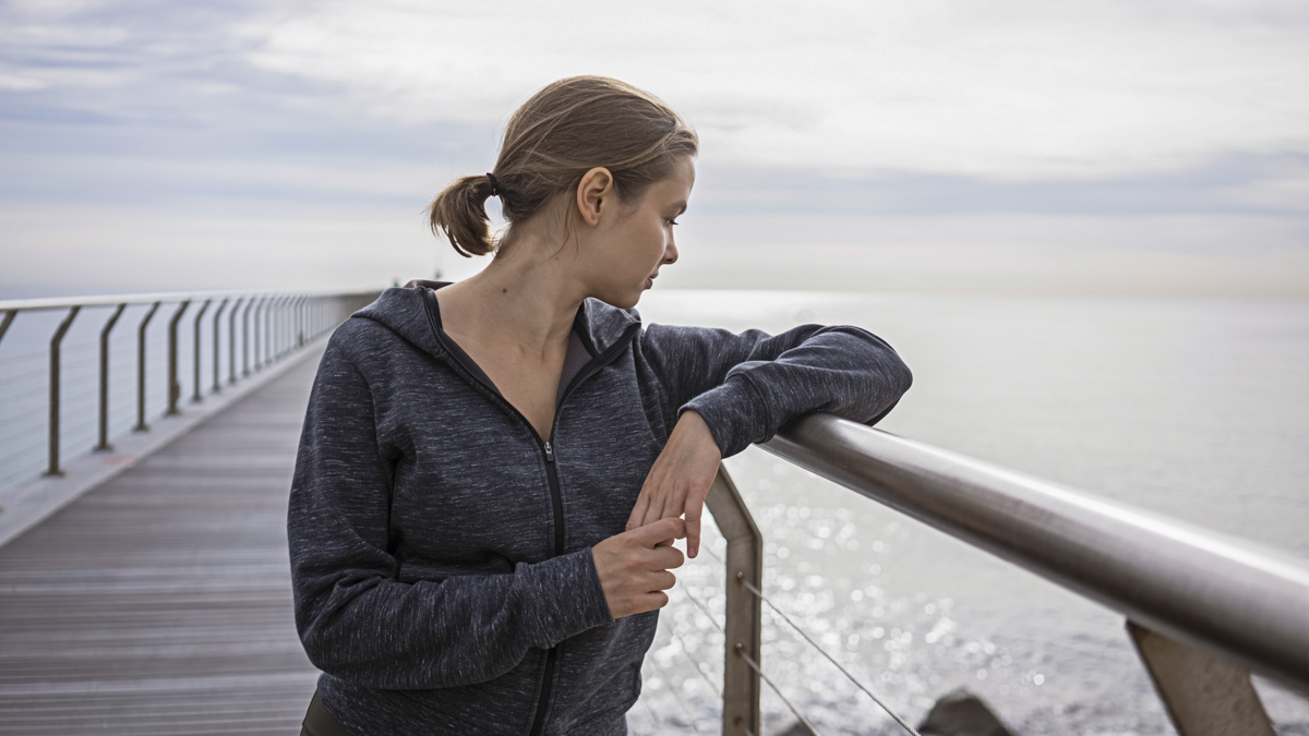 Young Athletic Woman In Sportswear Standing On The Bridge During