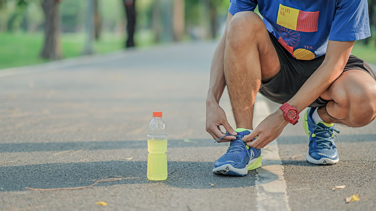 Young Athlete Man Tying Running Shoes In The Park Outdoor, Male