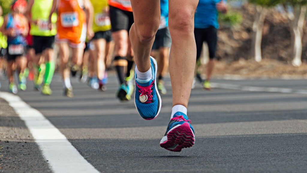 image of a woman's legs running in a marathon race and completing endurance training for women