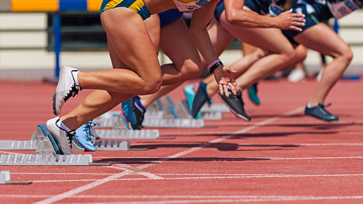 Group Of Female Track Athletes On Starting Blocks