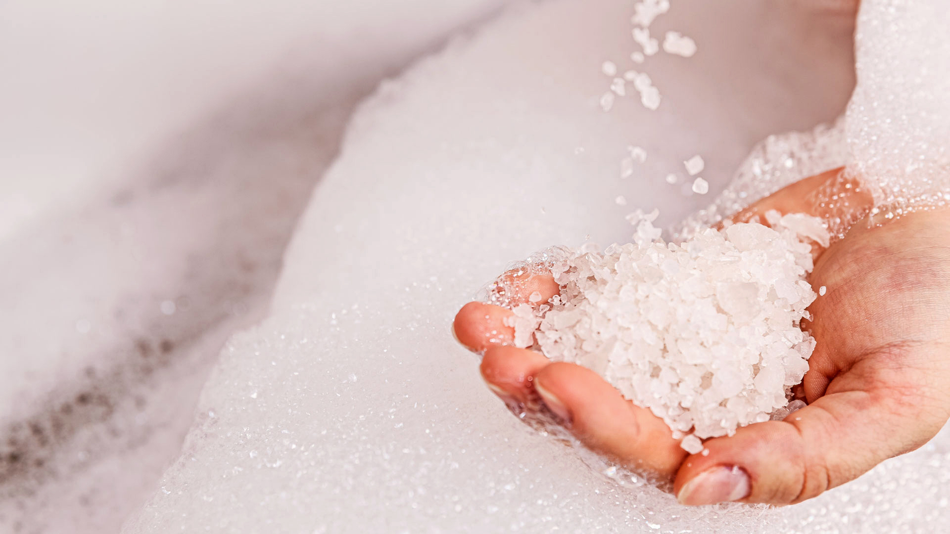 White Bath Salt In A Female Hand