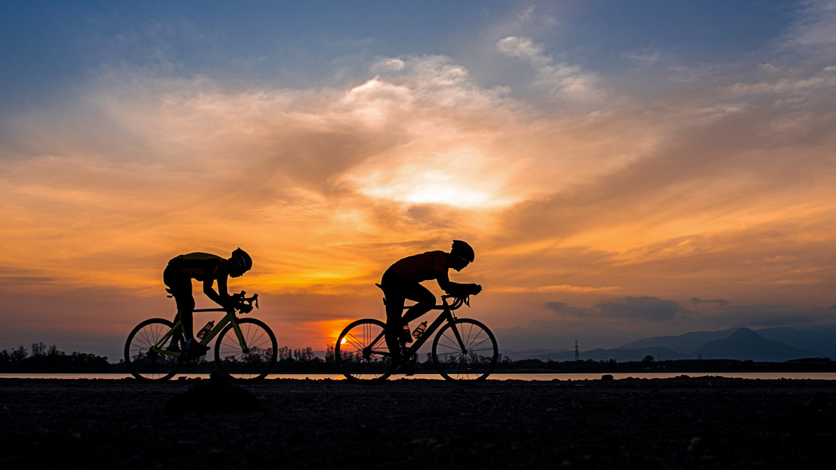 Silhouette Two Road Bike Cyclist Man Cycling In The Morning.