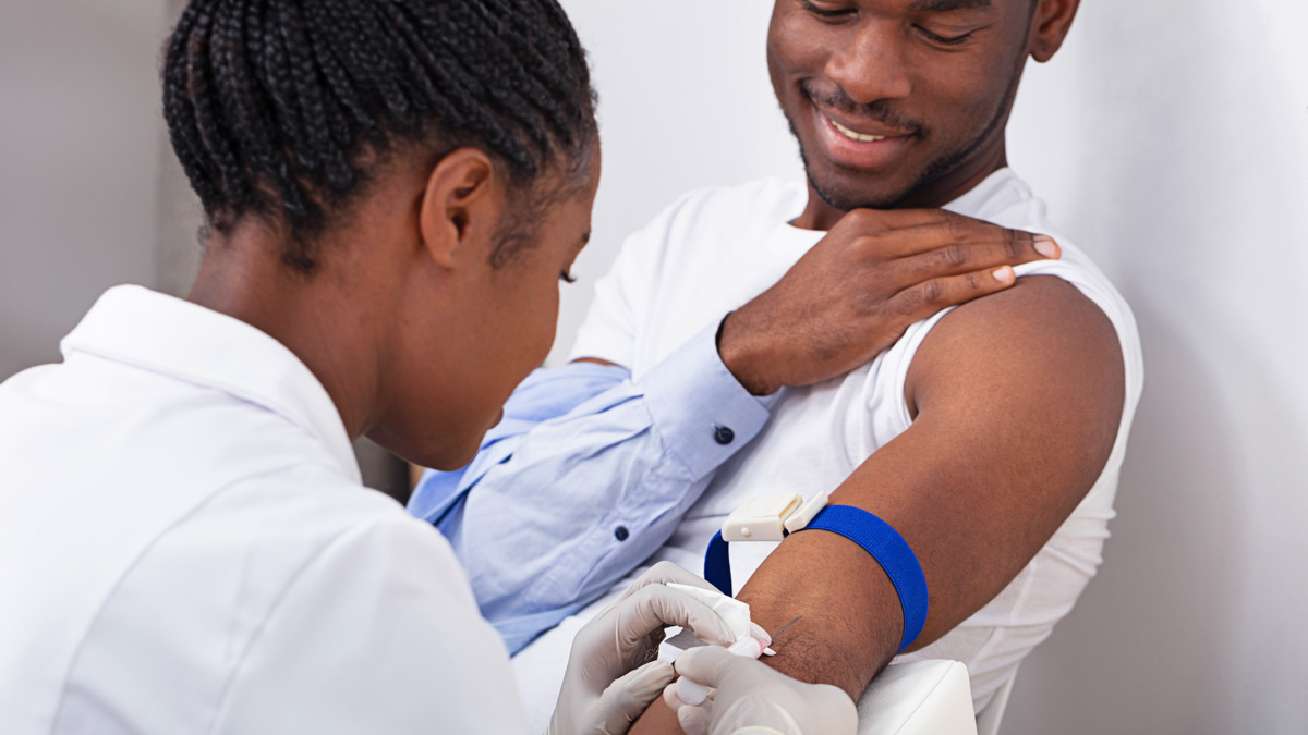 Doctor Injecting Patient With Syringe To Collect Blood