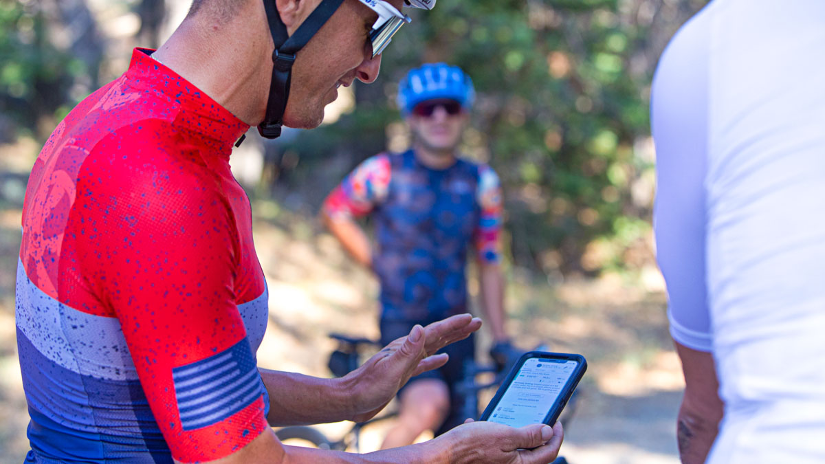 Male Cyclist In Red Jersey Looks At The Trainingpeaks App On His Phone After A Fitness Test