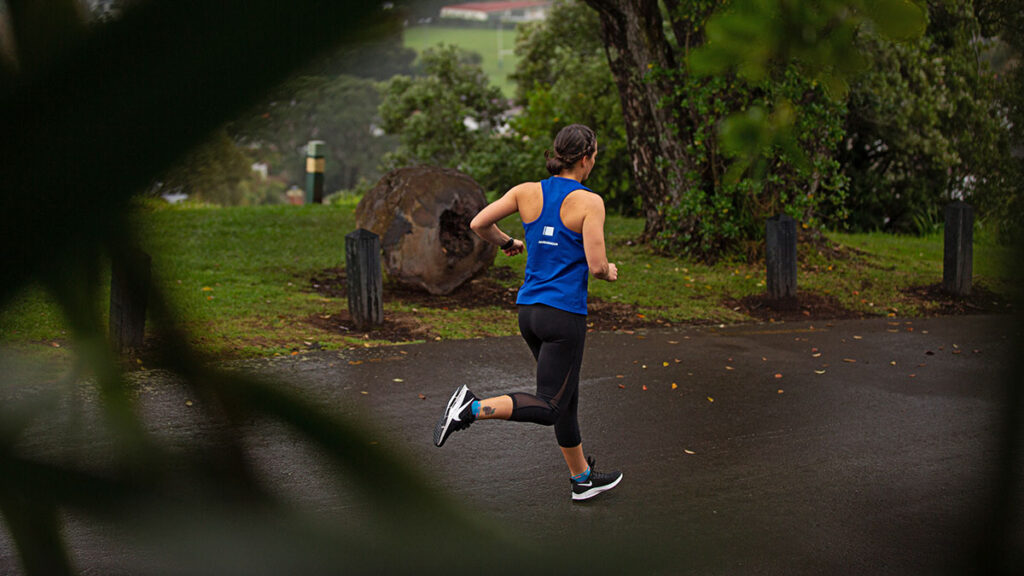 a woman running on a multi-user path in the rain