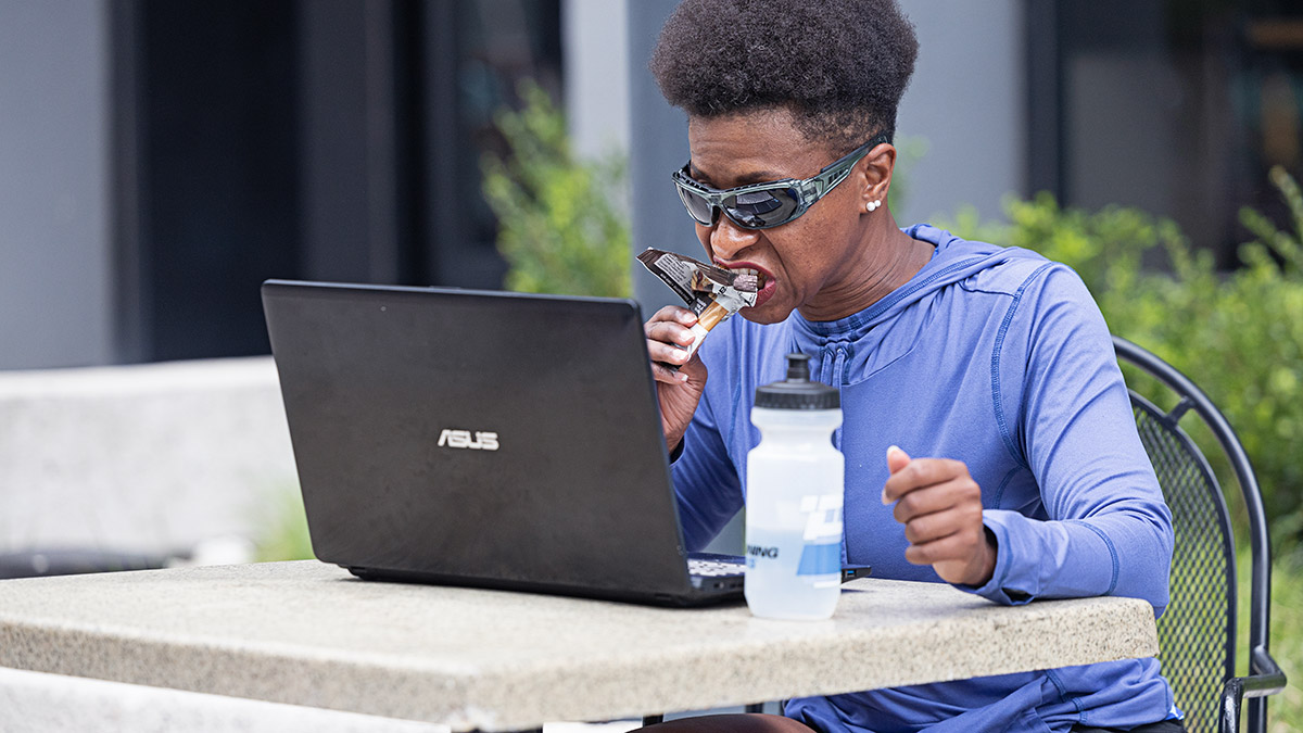 Athlete Fueling For Workout While Looking At Her Laptop Reviewing Her Past Workouts