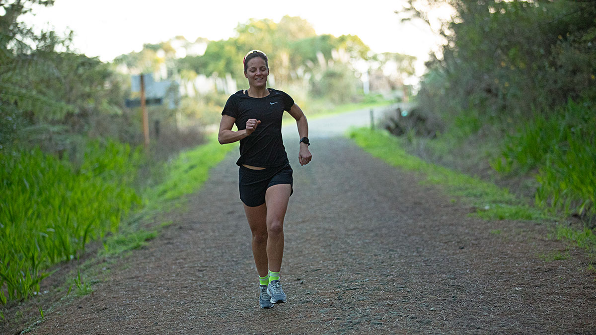 Female Athlete Running Along Dirt Trail In The Spring