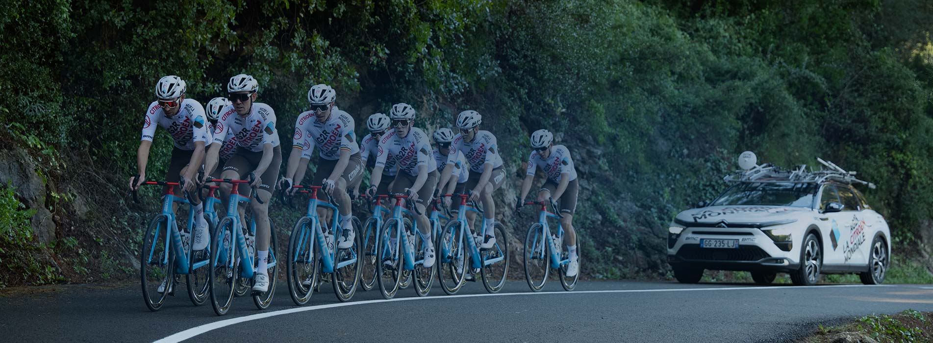 Team Of Cyclists Riding Up A Mountain Road