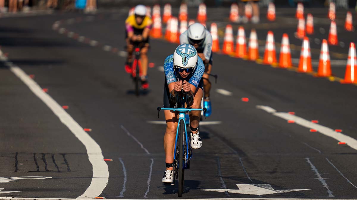 A Female Triathlete Rides Away From Two Competitors During The Kona World Championships In 2022