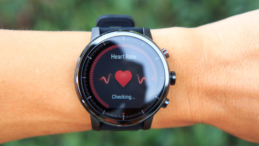 a smartwatch on the wrist of a person showing a heart symbol and waiting to read the heart rate