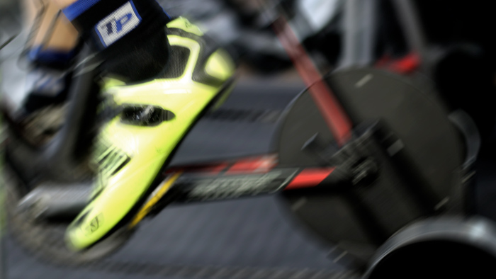 Image Of A Cyclist's Cleats As The Cyclist Does An Indoor Cycling Workout On His Trainer