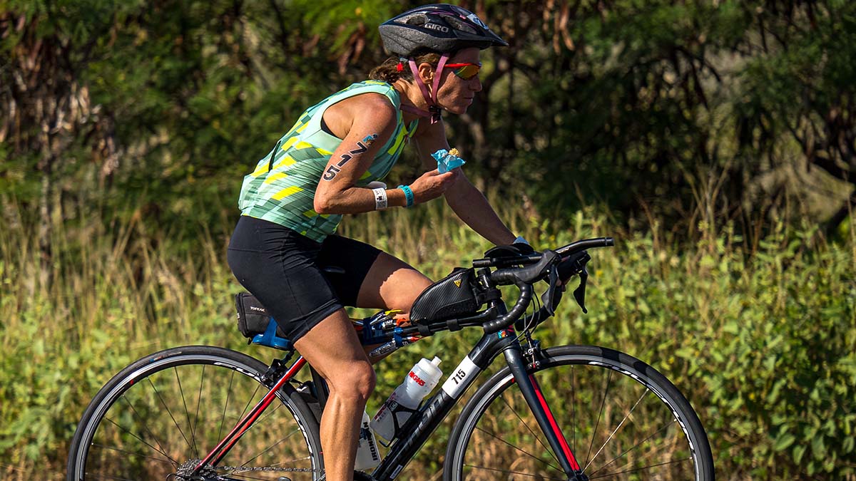 A Woman Eating An Energy Bar During An Ironman Race On Her Bike