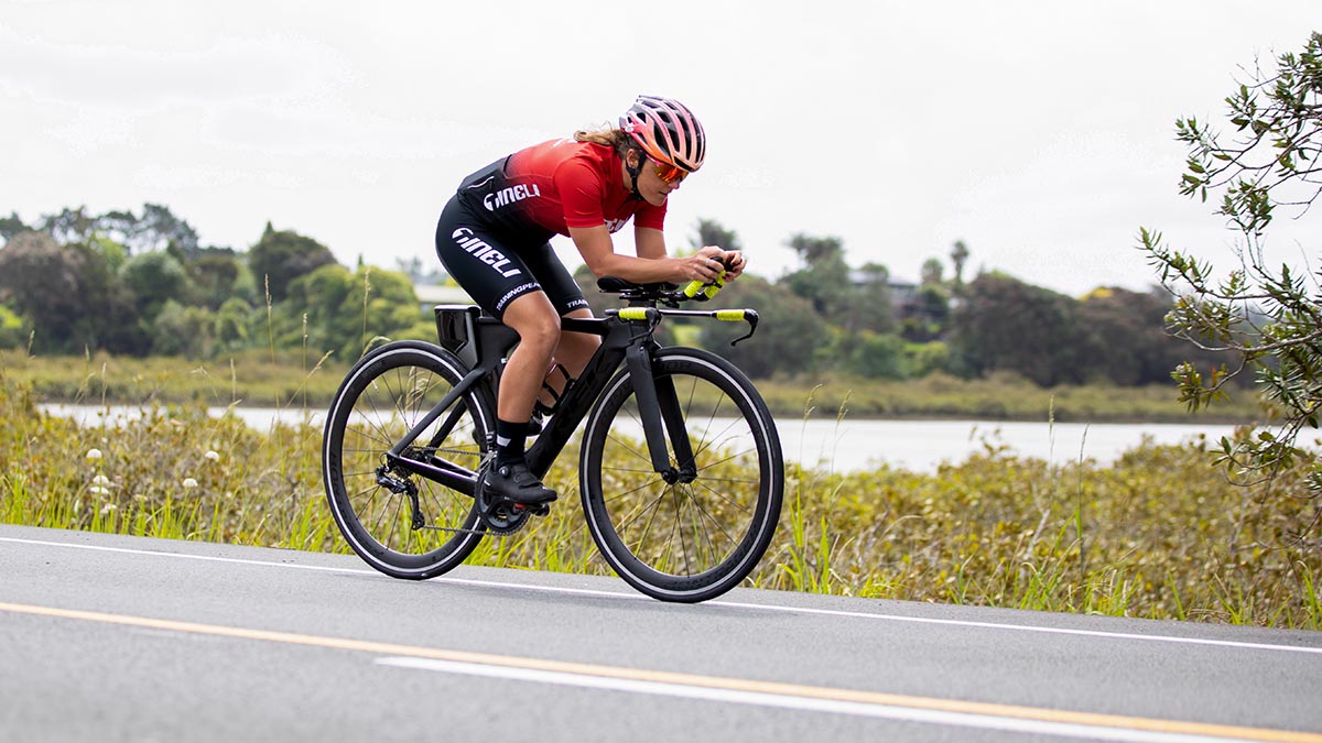 A Woman On A Time Trail Bike On The Aero Bars Riding On A Road