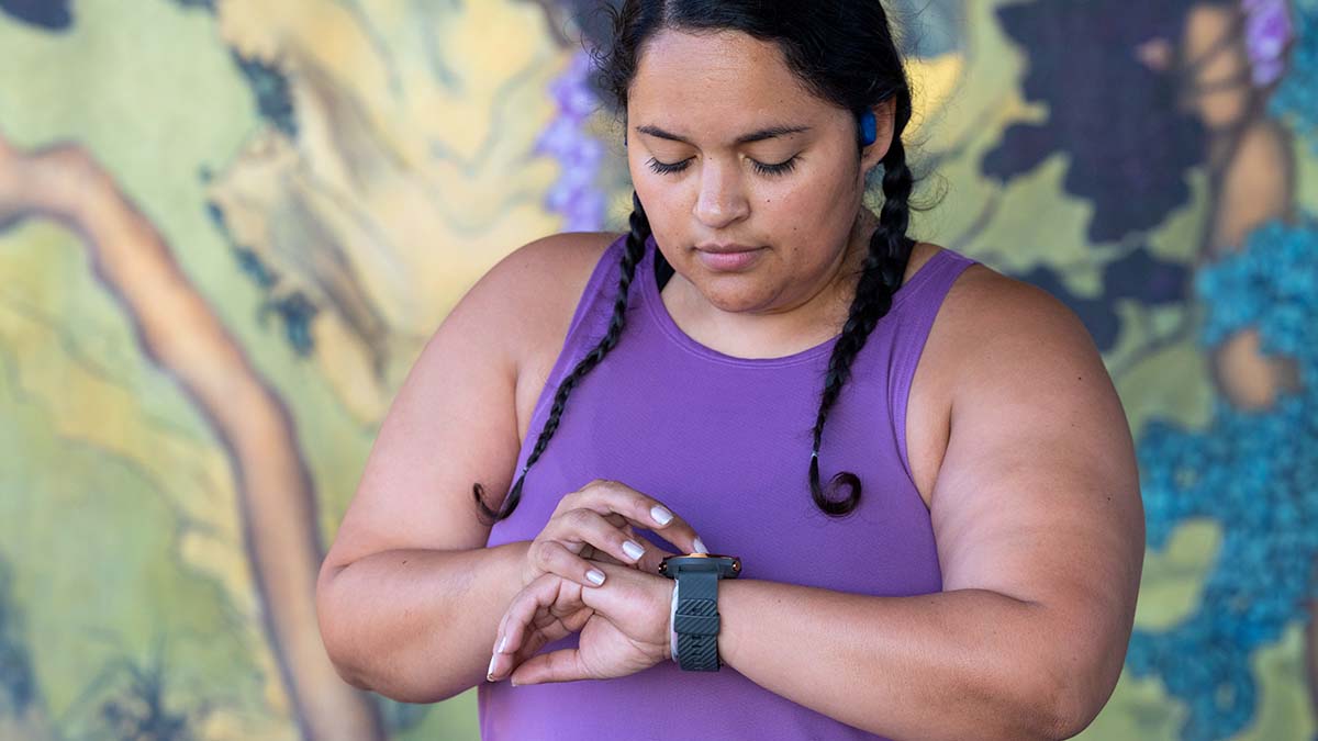 A Woman Looking At Her Wearable Device Measuring Her Heart Rate For Hrv Tracking