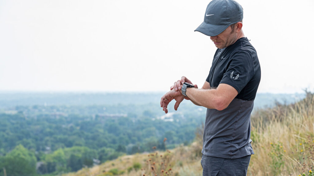 male athlete analyzing data on a smartwatch