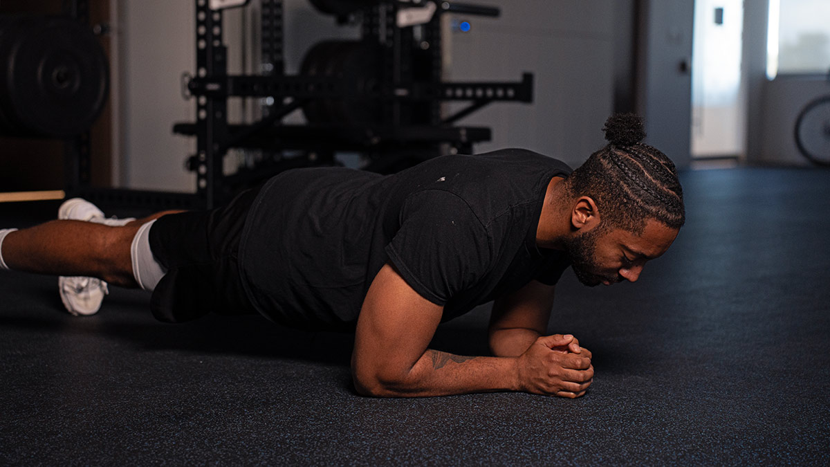 Diverse Male Athlete Downward Plank During A Strength Training Workout