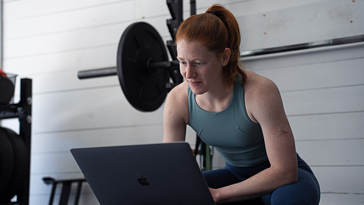 Female Coach Programming Strength Training On Her Laptop