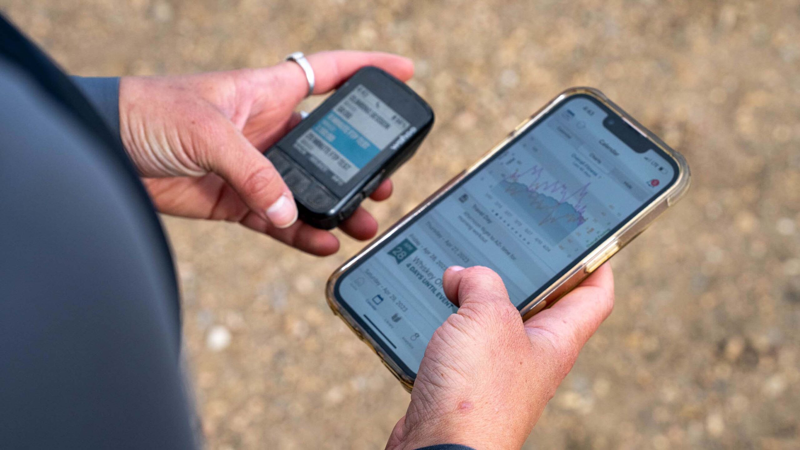 A Cyclist Holding Her Iphone And Wahoo Head Unit Looking At Data